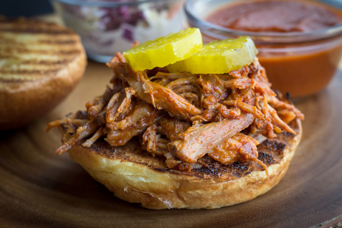 Grilled bun topped with BBQ shredded Pork and Pickles