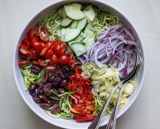 Overhead view of Mediterranean Zucchini Noodle Salad Bowl with Spoon and Fork