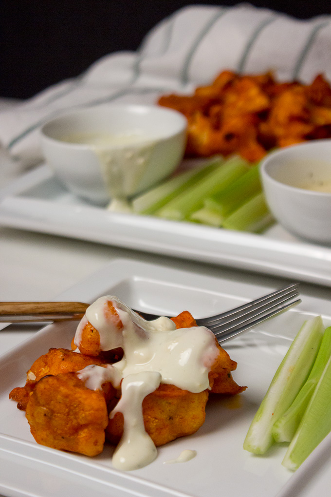 A Served Paleo Buffalo Cauliflower Bites Sprinkled with Ranch Sauce