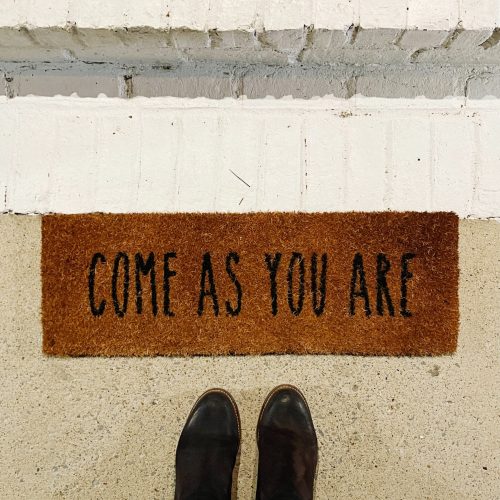 Come as you are doormat with person standing in front
